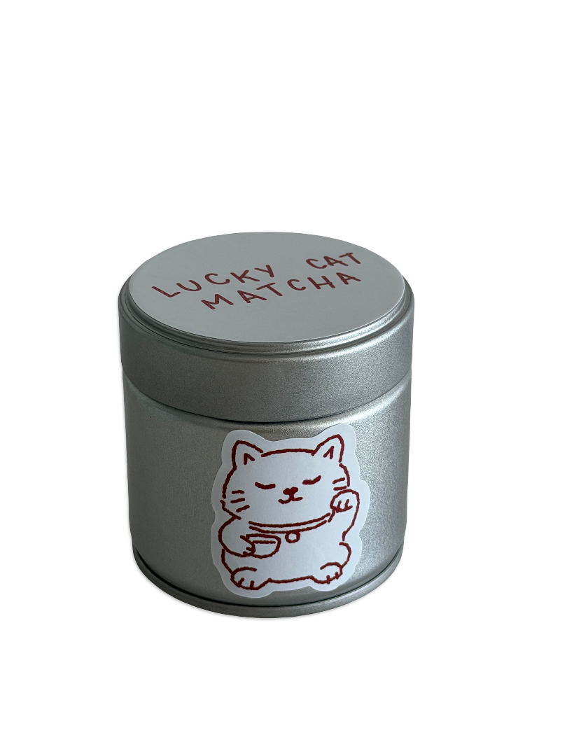 Silver container labeled 'Lucky Cat Matcha' with a cat illustration on a white background